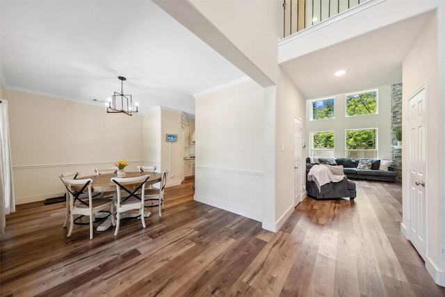 14619 Hampton Green Ln, Houston, TX 77044 - dining room featuring a chandelier, wood finished floors, ornamental molding, baseboards, and a towering ceiling