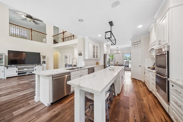 14619 Hampton Green Ln, Houston, TX 77044 - kitchen featuring stainless steel appliances, a sink, a center island, a peninsula, and white cabinetry