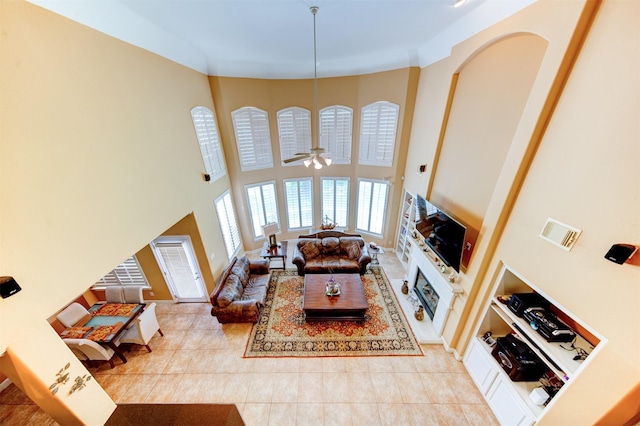 4815 N Pine Brook Way, Houston, TX 77059 - living area with light tile patterned flooring, built in shelves, a towering ceiling, ceiling fan, and a fireplace