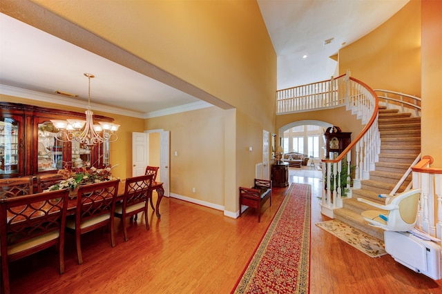 4815 N Pine Brook Way, Houston, TX 77059 - dining area with arched walkways, wood finished floors, stairs, a chandelier, and a towering ceiling