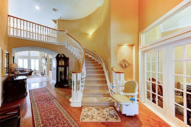 4815 N Pine Brook Way, Houston, TX 77059 - stairs with arched walkways, wood finished floors, and a high ceiling