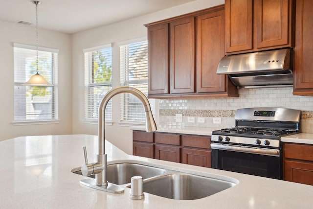 2813 Bottiglia Way, League City, TX 77573 - kitchen featuring stainless steel gas range, under cabinet range hood, light countertops, and decorative backsplash