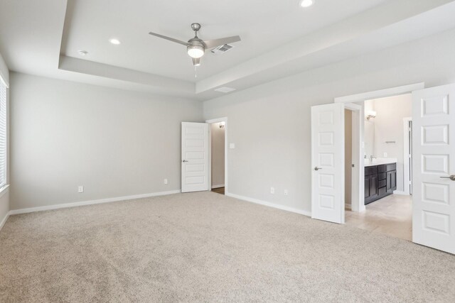 29211 Pikes Peak Dr, Katy, TX 77494 - unfurnished bedroom with light colored carpet, baseboards, recessed lighting, a tray ceiling, and connected bathroom