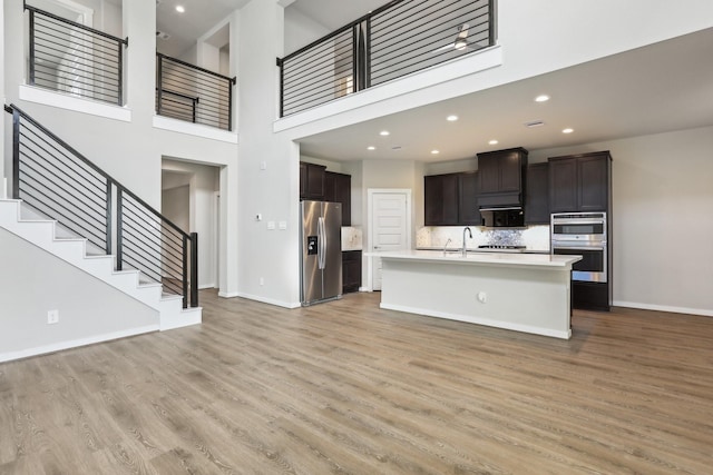 29211 Pikes Peak Dr, Katy, TX 77494 - kitchen featuring appliances with stainless steel finishes, light countertops, baseboards, light wood-style flooring, and a sink