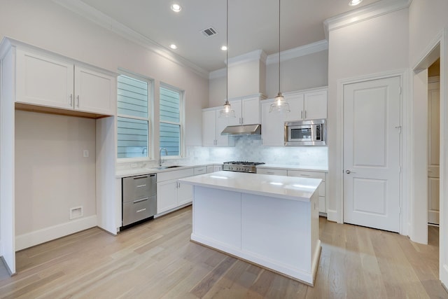 8710 Park Kolbe Ln, Houston, TX 77080 - kitchen with stainless steel appliances, under cabinet range hood, crown molding, backsplash, and white cabinets