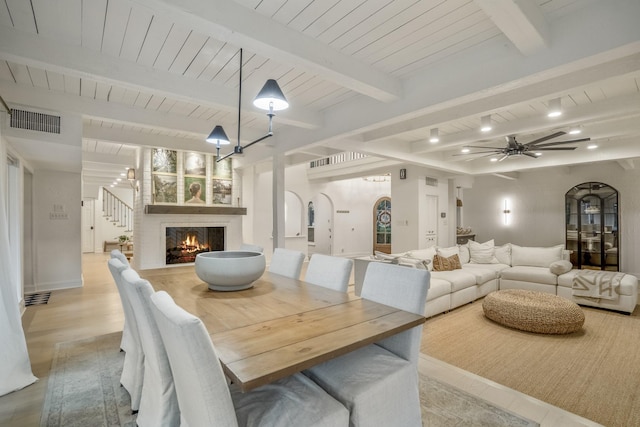 11 Twin Circle Dr, Houston, TX 77042 - dining area with arched walkways, wooden ceiling with exposed beams, a fireplace, stairway, and a ceiling fan