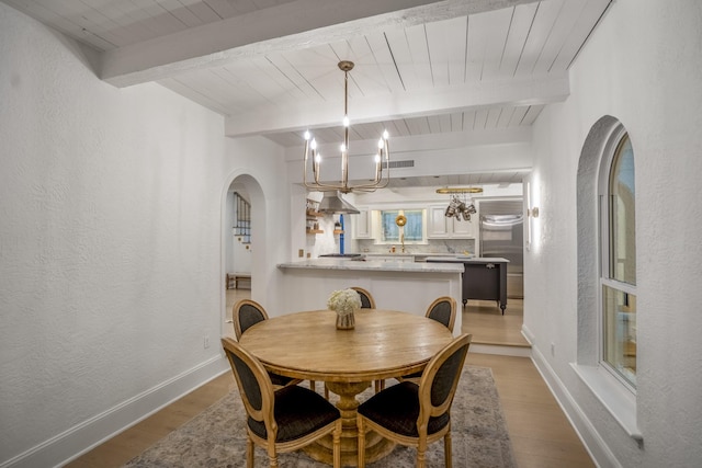 11 Twin Circle Dr, Houston, TX 77042 - dining room with a chandelier, light wood-style flooring, wooden ceiling with exposed beams, a textured wall, and baseboards