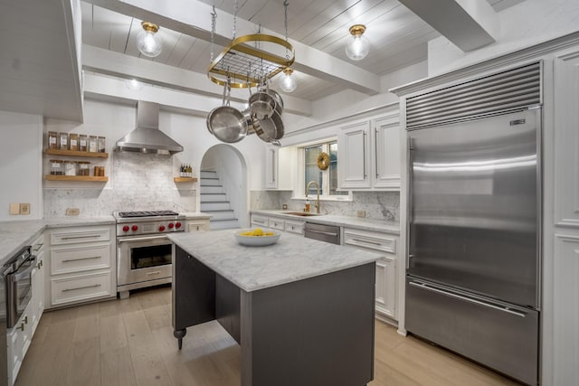 11 Twin Circle Dr, Houston, TX 77042 - kitchen featuring high end appliances, wall chimney exhaust hood, a sink, open shelves, and tasteful backsplash