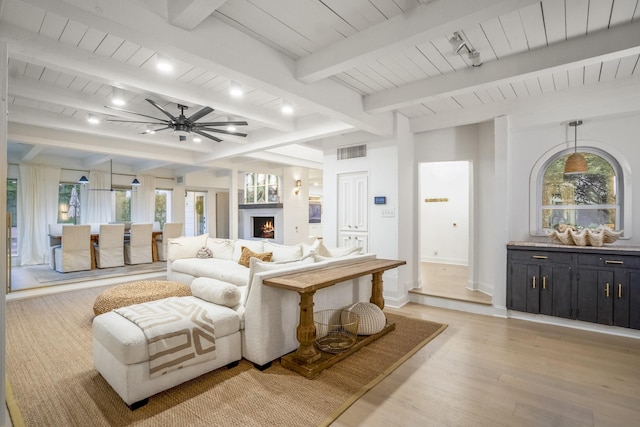 11 Twin Circle Dr, Houston, TX 77042 - living area featuring light wood-style floors, a ceiling fan, wood ceiling with exposed beams, a warm lit fireplace, and rail lighting