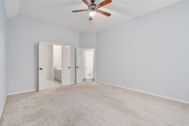 19315 Oak Station Dr, Humble, TX 77346 - unfurnished bedroom featuring connected bathroom, light carpet, baseboards, and lofted ceiling