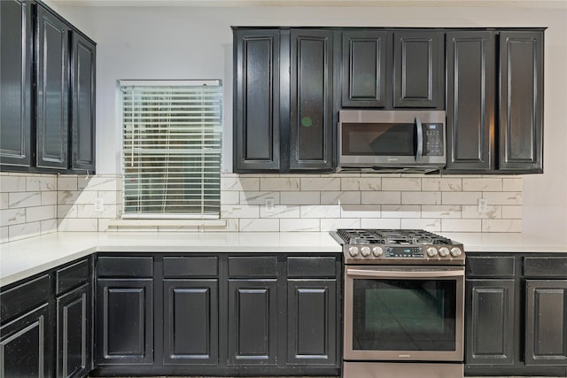 19315 Oak Station Dr, Humble, TX 77346 - kitchen featuring appliances with stainless steel finishes, tasteful backsplash, light countertops, and dark cabinets