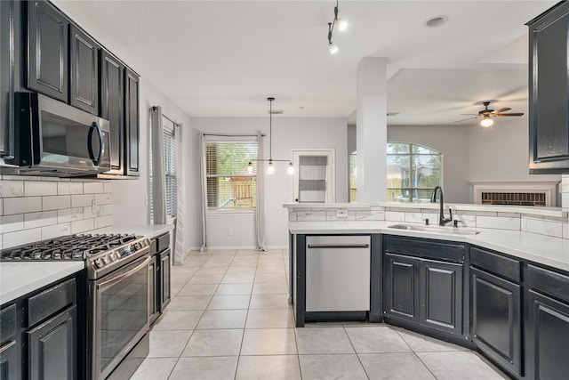 19315 Oak Station Dr, Humble, TX 77346 - kitchen featuring stainless steel appliances, a sink, backsplash, ceiling fan, and light countertops