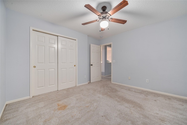 19315 Oak Station Dr, Humble, TX 77346 - unfurnished bedroom featuring carpet, baseboards, a closet, ceiling fan, and a textured ceiling