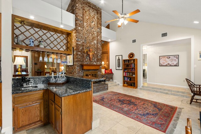 815 Millpond Dr, Sugar Land, TX 77498 - kitchen featuring a ceiling fan, high vaulted ceiling, dark stone counters, brown cabinets, and light tile patterned floors