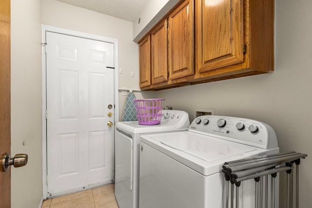 815 Millpond Dr, Sugar Land, TX 77498 - laundry room featuring cabinet space, washing machine and clothes dryer, light tile patterned flooring, and a textured ceiling