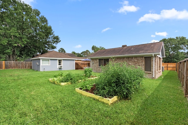 815 Millpond Dr, Sugar Land, TX 77498 - back of property with brick siding, a fenced backyard, a vegetable garden, and a shingled roof