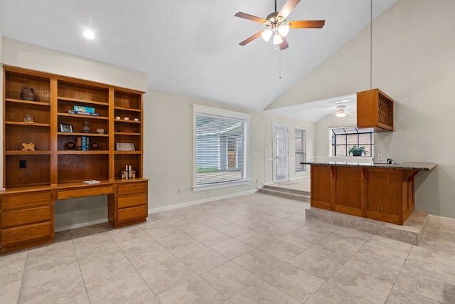 815 Millpond Dr, Sugar Land, TX 77498 - kitchen with ceiling fan, brown cabinetry, a peninsula, light tile patterned floors, and high vaulted ceiling