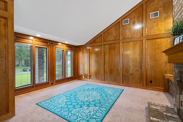 815 Millpond Dr, Sugar Land, TX 77498 - unfurnished living room with a fireplace with raised hearth, light colored carpet, wooden walls, high vaulted ceiling, and recessed lighting