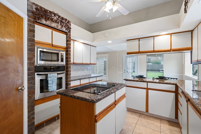 815 Millpond Dr, Sugar Land, TX 77498 - kitchen featuring appliances with stainless steel finishes, white cabinetry, a ceiling fan, tasteful backsplash, and dark stone counters