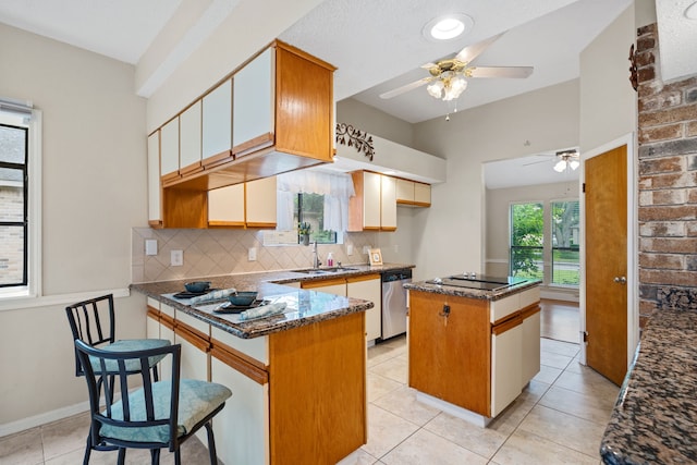 815 Millpond Dr, Sugar Land, TX 77498 - kitchen featuring dishwasher, a ceiling fan, a peninsula, a kitchen island, and tasteful backsplash