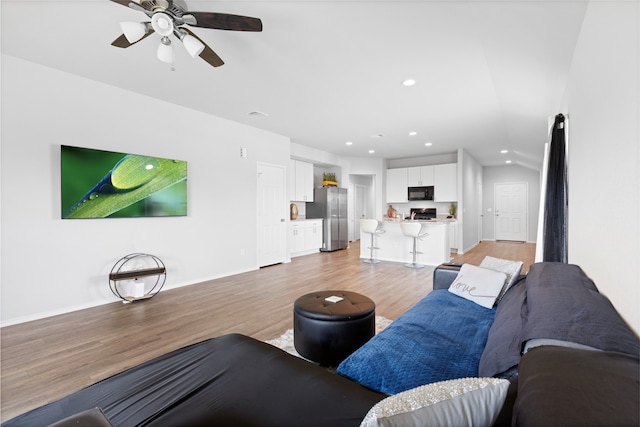 10530 Vinca Minor Ln, Houston, TX 77016 - living room featuring light wood-style floors, recessed lighting, a ceiling fan, baseboards, and lofted ceiling