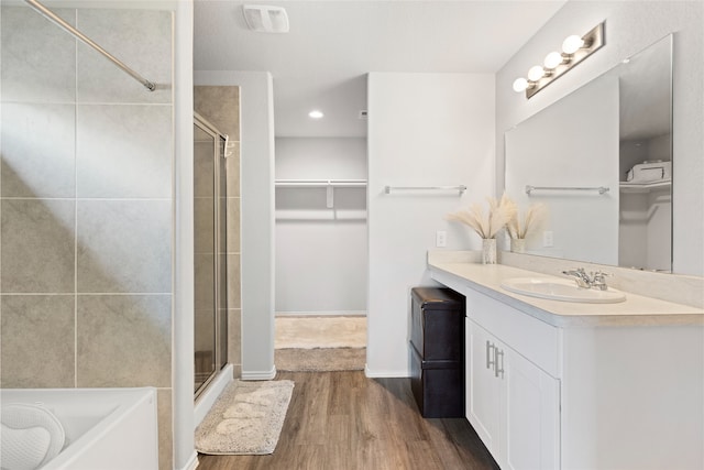 10530 Vinca Minor Ln, Houston, TX 77016 - full bath featuring a walk in closet, a stall shower, vanity, wood finished floors, and a garden tub
