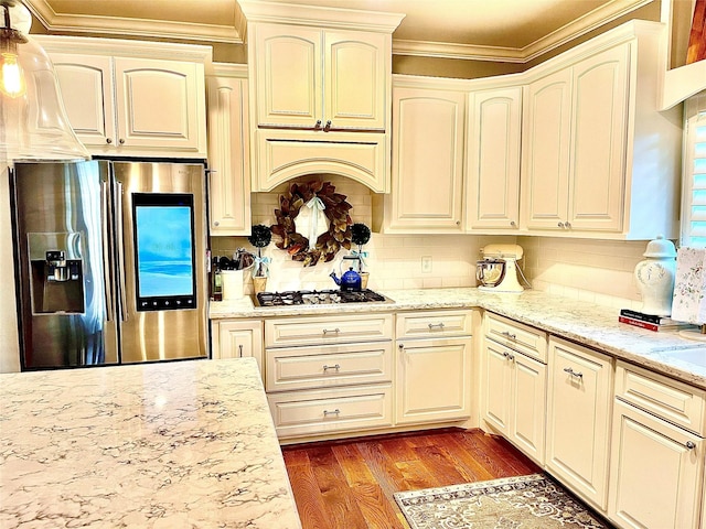 3898 County Road 135th Rd, Wharton, TX 77488 - kitchen with stainless steel fridge with ice dispenser, gas stovetop, ornamental molding, wood finished floors, and light stone countertops