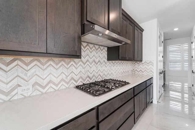 9818 Daffodil Springs Dr, Richmond, TX 77407 - kitchen with extractor fan, stainless steel gas stovetop, dark brown cabinets, light countertops, and decorative backsplash