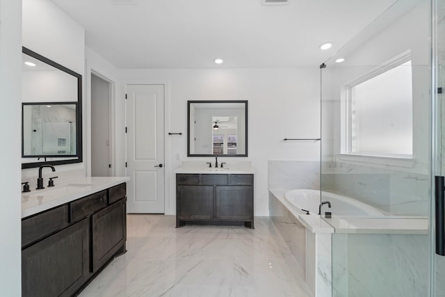 9818 Daffodil Springs Dr, Richmond, TX 77407 - full bathroom with a garden tub, two vanities, recessed lighting, and marble finish flooring
