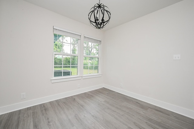 226 Hyta St, Houston, TX 77018 - spare room featuring a chandelier, baseboards, and wood finished floors