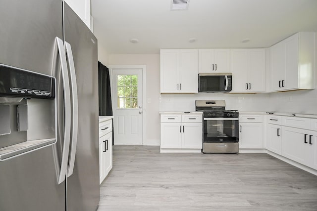 226 Hyta St, Houston, TX 77018 - kitchen featuring stainless steel appliances, light countertops, white cabinetry, light wood finished floors, and baseboards