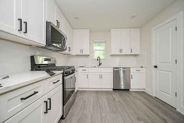 226 Hyta St, Houston, TX 77018 - kitchen with appliances with stainless steel finishes, a sink, light wood-style floors, and tasteful backsplash