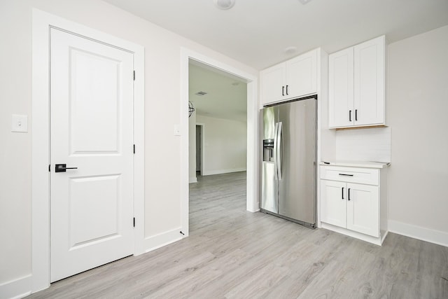 226 Hyta St, Houston, TX 77018 - kitchen with stainless steel refrigerator with ice dispenser, light wood-type flooring, white cabinetry, baseboards, and light countertops
