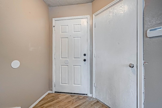 1406 Hade Falls Ln, Houston, TX 77073 - doorway featuring light wood finished floors, baseboards, and a textured ceiling