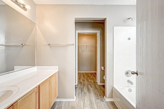 1406 Hade Falls Ln, Houston, TX 77073 - bathroom with vanity, wood finished floors, a spacious closet, and baseboards