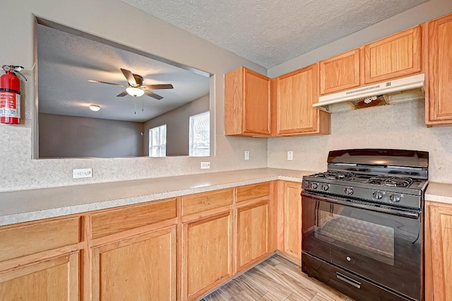 1406 Hade Falls Ln, Houston, TX 77073 - kitchen featuring black gas range oven, under cabinet range hood, light countertops, ceiling fan, and a textured ceiling