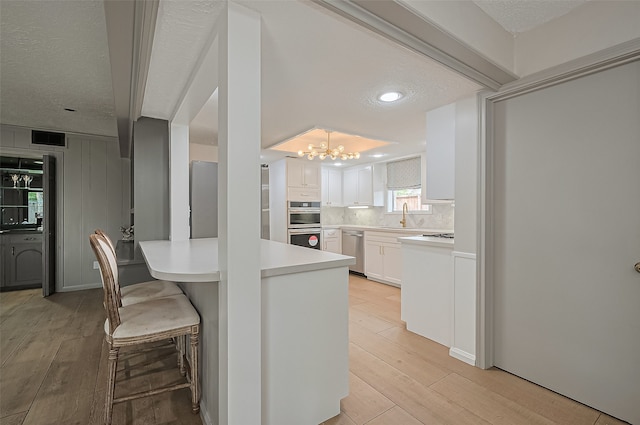 13622 Indian Creek Rd, Houston, TX 77079 - kitchen featuring a chandelier, a sink, light wood-style flooring, light countertops, and appliances with stainless steel finishes