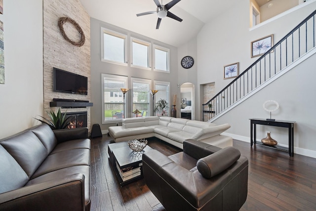 6218 Southcott Ct, Katy, TX 77450 - living room with high vaulted ceiling, a ceiling fan, a fireplace, arched walkways, and dark wood finished floors