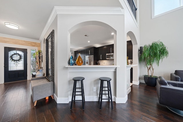 6218 Southcott Ct, Katy, TX 77450 - entryway featuring dark wood-style flooring, healthy amount of natural light, ornamental molding, arched walkways, and baseboards