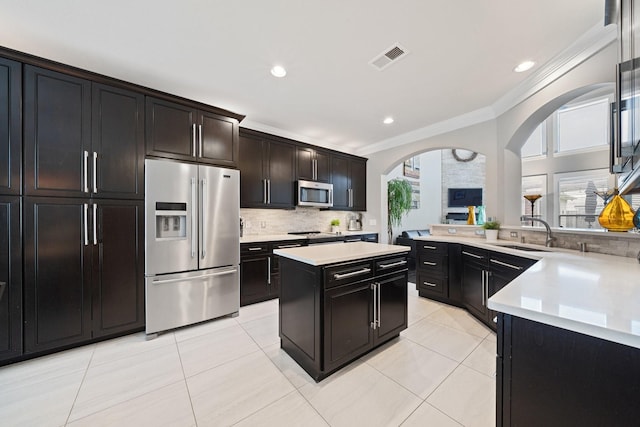 6218 Southcott Ct, Katy, TX 77450 - kitchen with appliances with stainless steel finishes, a sink, crown molding, tasteful backsplash, and light countertops