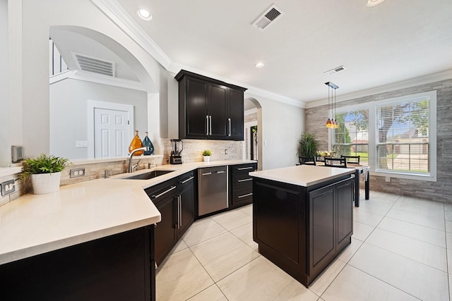 6218 Southcott Ct, Katy, TX 77450 - kitchen with a sink, arched walkways, crown molding, light countertops, and dark cabinets