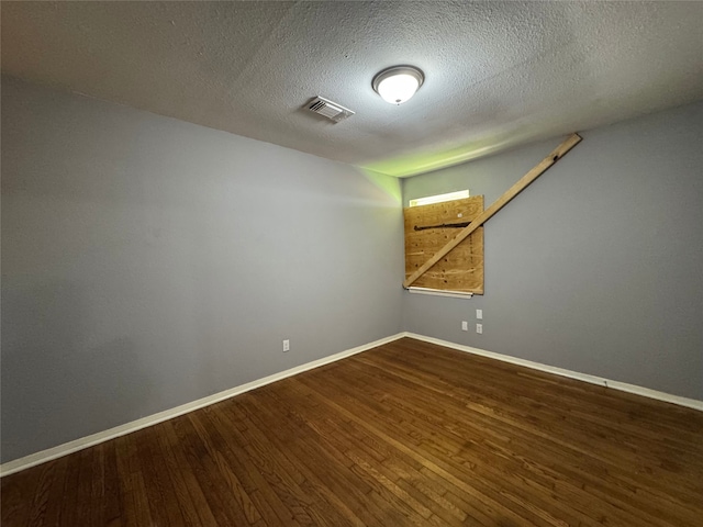 10509 Kelburn Dr, Houston, TX 77016 - empty room featuring wood finished floors, baseboards, and a textured ceiling