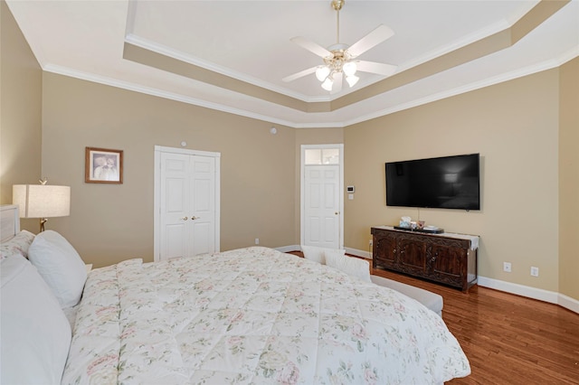 17814 Shady Arbor Way, Spring, TX 77379 - bedroom featuring a tray ceiling, wood finished floors, crown molding, baseboards, and a ceiling fan