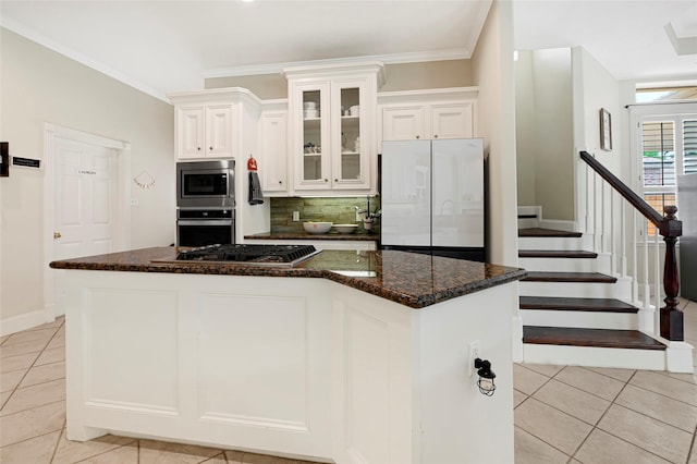 17814 Shady Arbor Way, Spring, TX 77379 - kitchen featuring stainless steel appliances, light tile patterned flooring, backsplash, white cabinets, and ornamental molding
