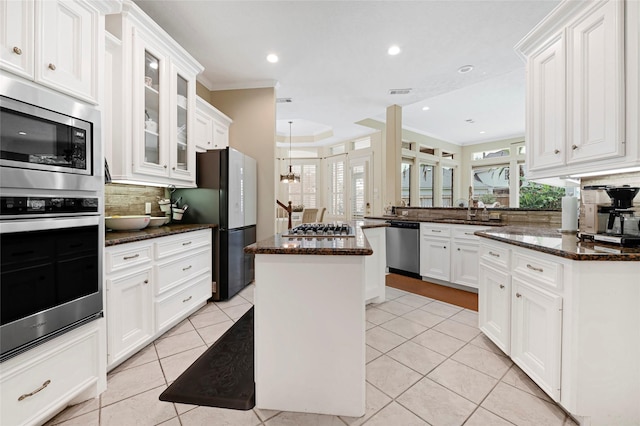 17814 Shady Arbor Way, Spring, TX 77379 - kitchen with appliances with stainless steel finishes, a peninsula, decorative backsplash, crown molding, and white cabinets