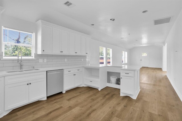 0 Basswood St, Houston, TX 77022 - kitchen featuring stainless steel dishwasher, a sink, a peninsula, light wood-style flooring, and healthy amount of natural light