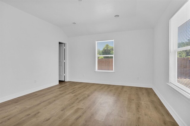 0 Basswood St, Houston, TX 77022 - empty room featuring healthy amount of natural light, light wood-style flooring, lofted ceiling, and baseboards