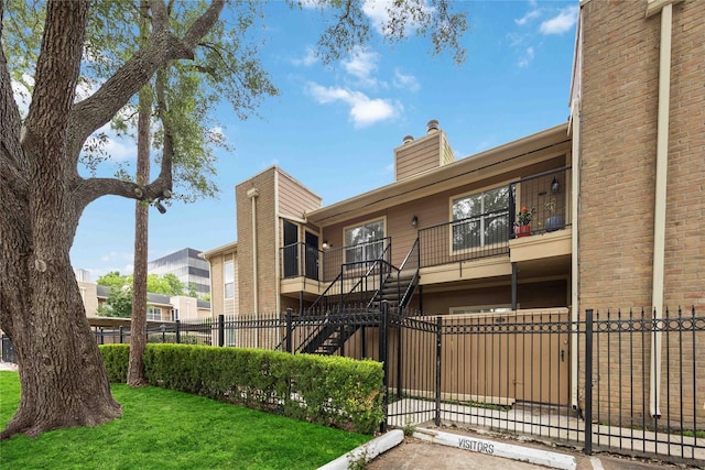 726 Bering Dr Unit F, Houston, TX 77057 - view of building exterior featuring a fenced front yard, stairs, and uncovered parking
