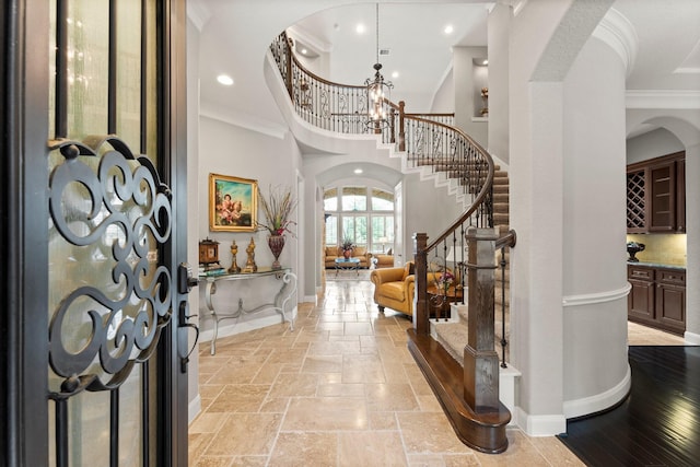 74 Spincaster Dr, Spring, TX 77389 - foyer entrance with arched walkways, ornamental molding, stairs, a high ceiling, and stone tile floors