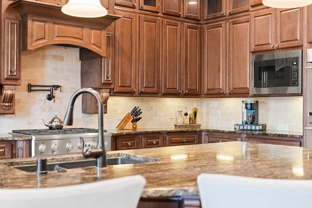 74 Spincaster Dr, Spring, TX 77389 - kitchen featuring built in microwave, stone counters, backsplash, and glass insert cabinets